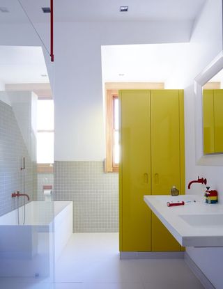 bathroom storage - tall yellow cabinet in white bathroom