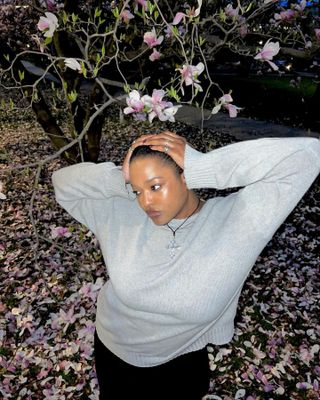 Imani Randolph posing outside with glowing skin and healthy brows.