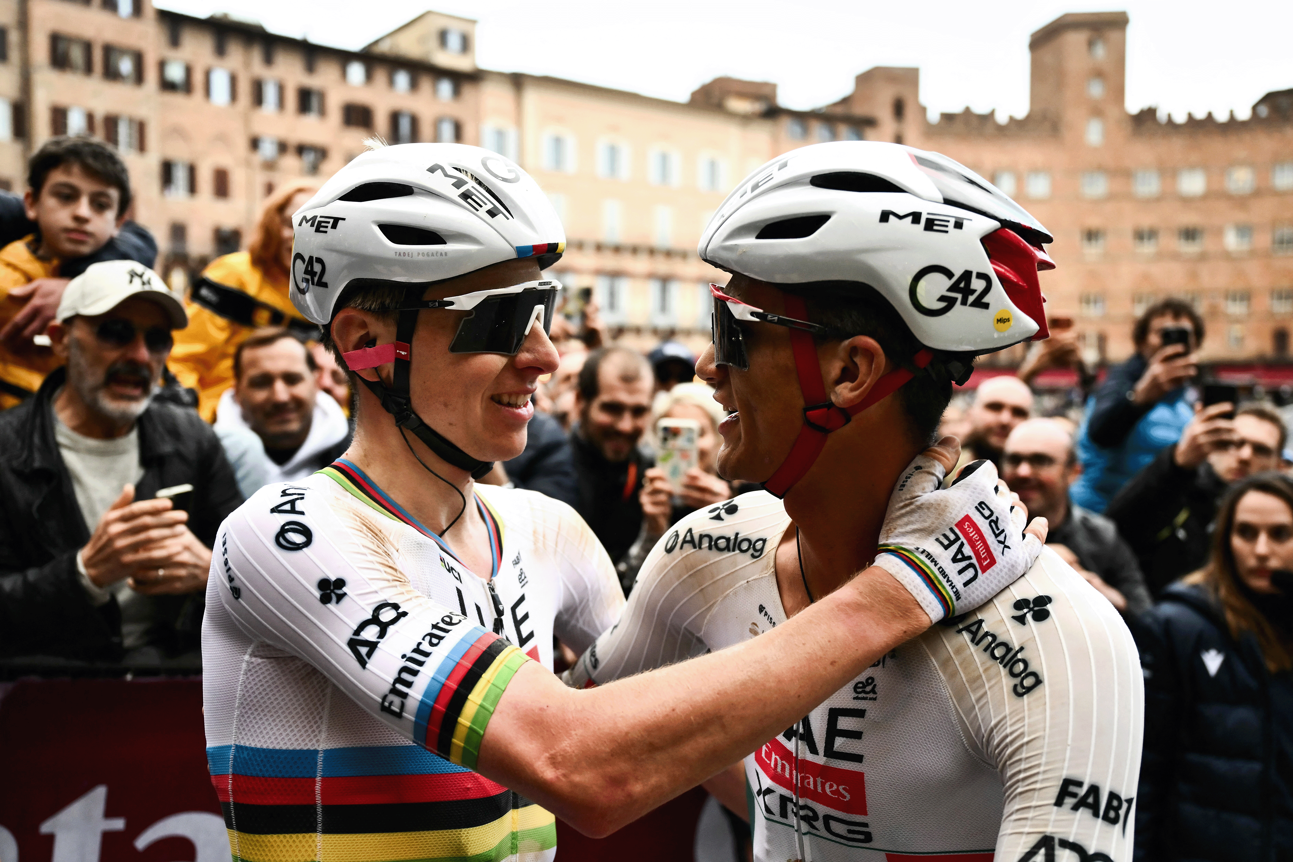 UAE Team Emirates's Slovenian Tadej Pogacar (L) celebrates with UAE Team Emirates's Mexican Isaac Del Toro Romero after winning the 20th one-day classic 'Strade Bianche' (White Roads) men's cycling race between Siena and Siena in Tuscany on March 7, 2026. (Photo by Marco BERTORELLO / AFP via Getty Images)