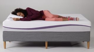 Best Purple mattress deals and discounts: A woman lies on her side on top of the original Purple Mattress