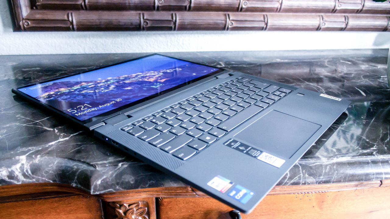 An open and powered on laptop lays flat on top of black marble countertop