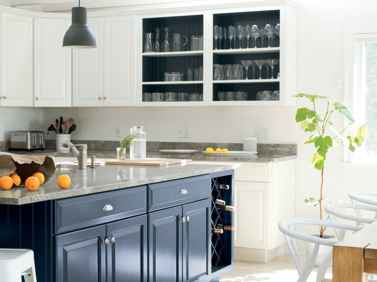 A kitchen painted a warm white shade with blue cabinets