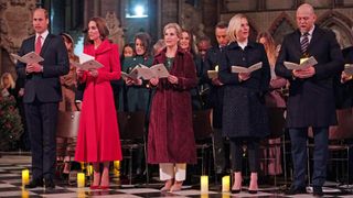 Prince William, Catherine, Princess of Wales, Duchess Sophie, Zara and Mike Tindall sing, holding song sheets, during the Together at Christmas carol service in 2021