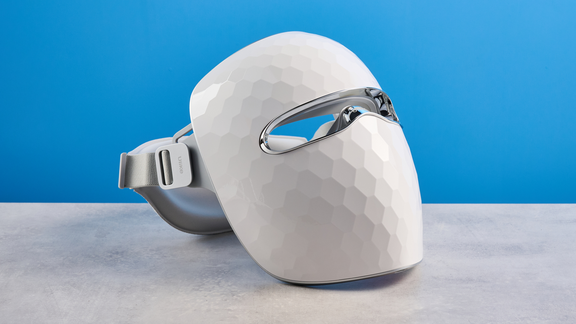 the ulike reglow led skincare mask showing its red LED light and control and charger