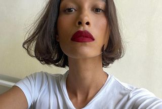 TyLynn Nguyen wearing white t-shirt and red lips with bob haircut, looking at camera