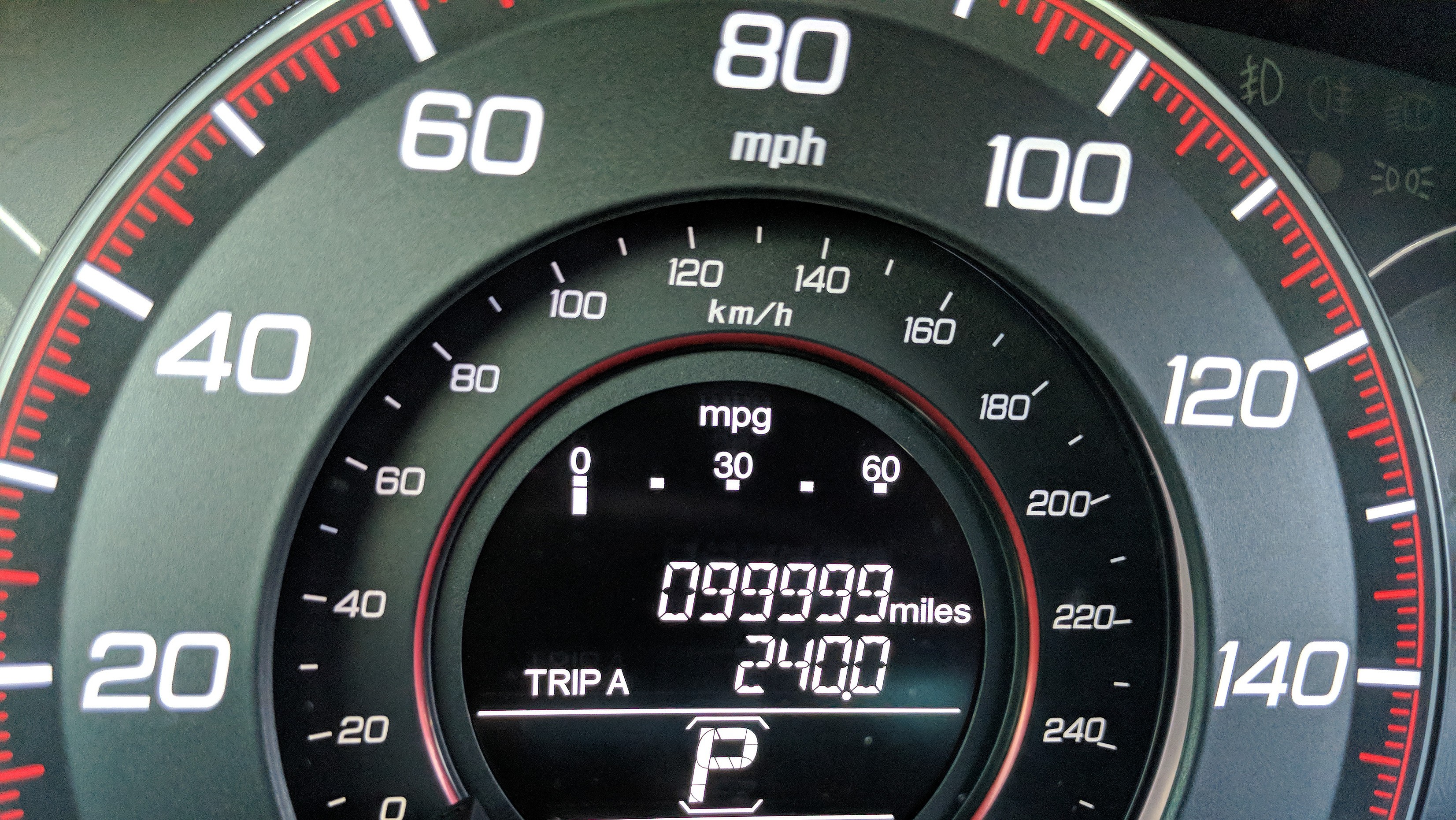 A car's odometer reading 99,999 miles.