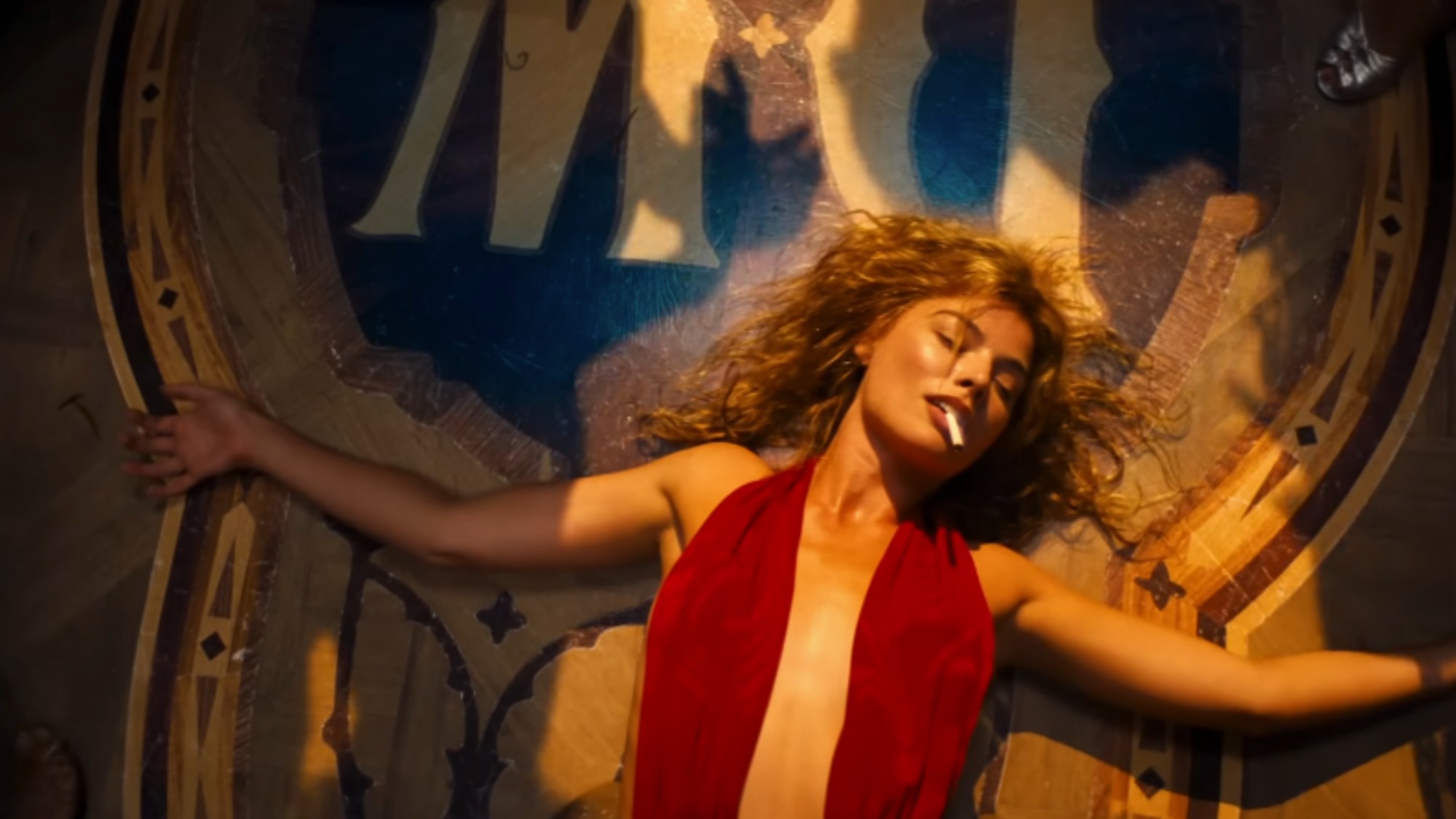 Margo Robbie in a revealing red dress with a cigarette in her mouth in Babylon