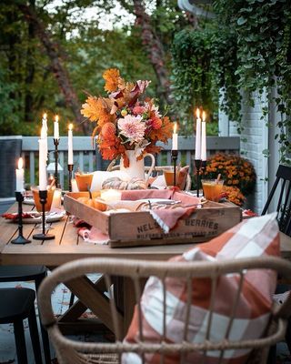 Outdoor dining table with wicker chairs and tapered candles