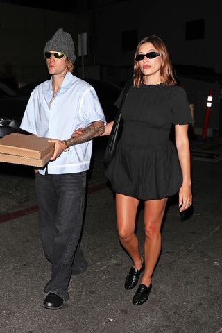 Justin e Hailey Bieber caminhando com uma caixa de pizza