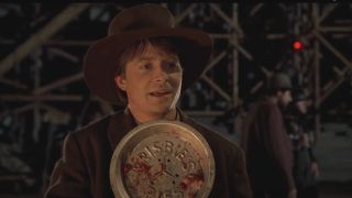 Michael J. Fox smiles while holding a frisbie pie plate in Back To The Future: Part III.