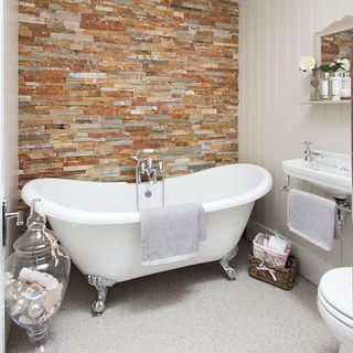 bathroom with white bathtub and commode