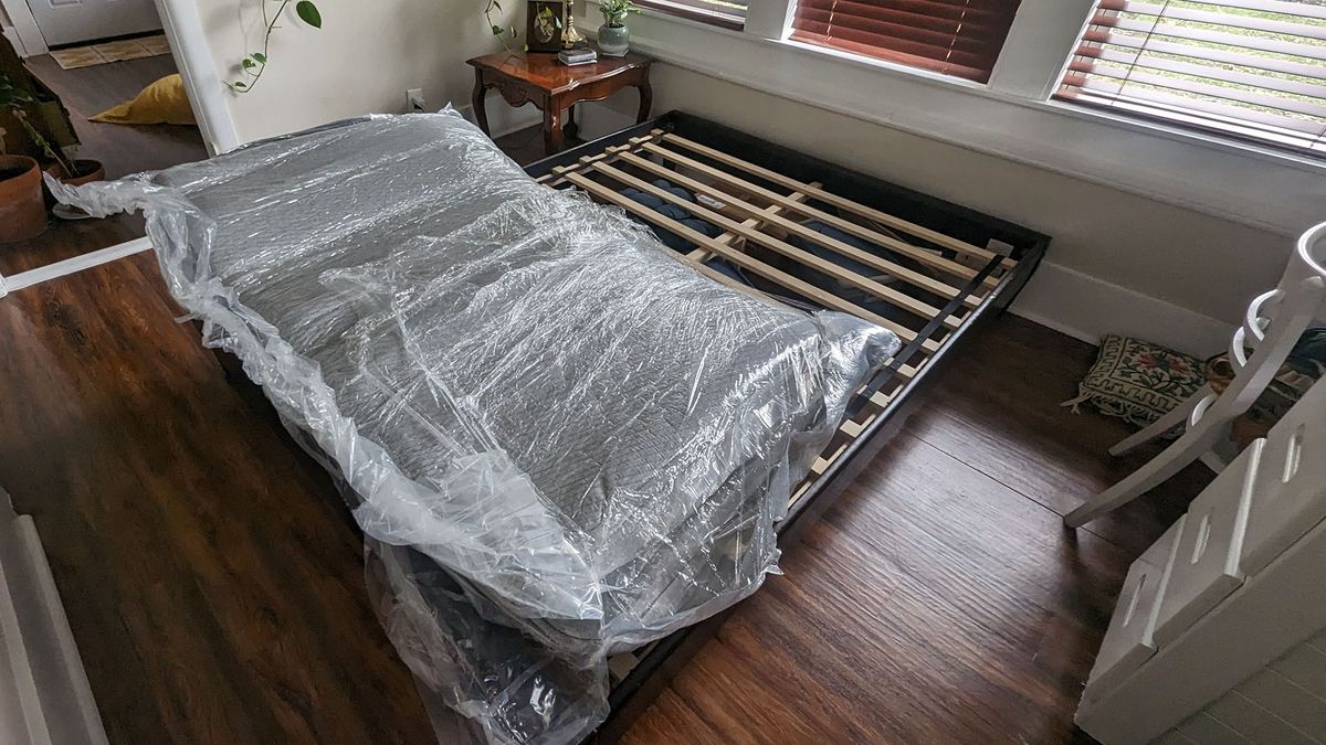 Casper Original mattress in its plastic wrapping on a bed frame