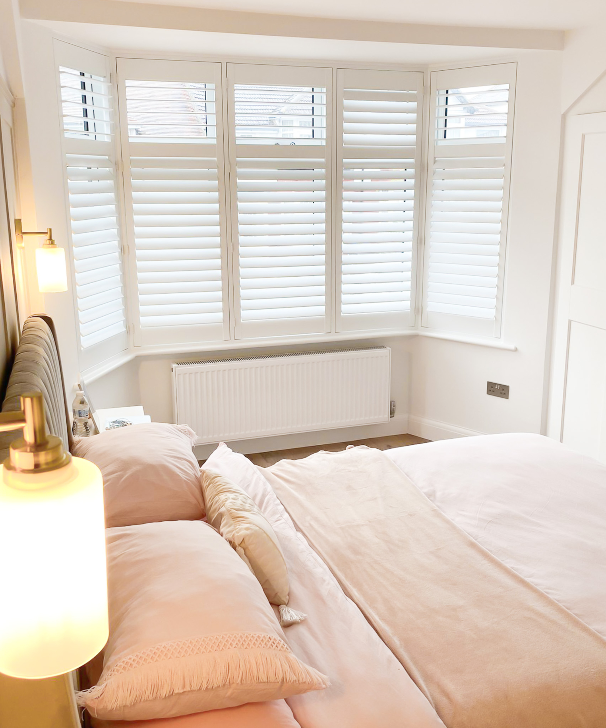 white radiator below bay window with white shutters