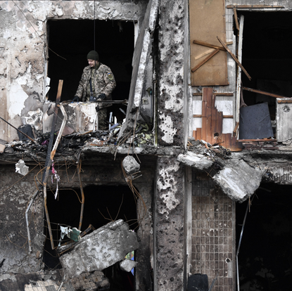 A person looks out at the destruction in Ukraine