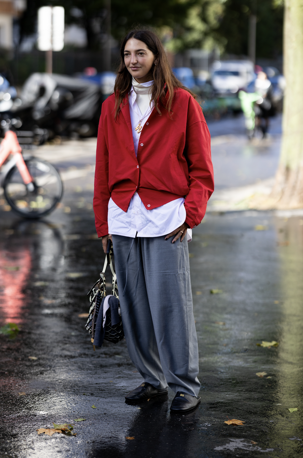 woman wearing red cardigan, white top, and gray pants