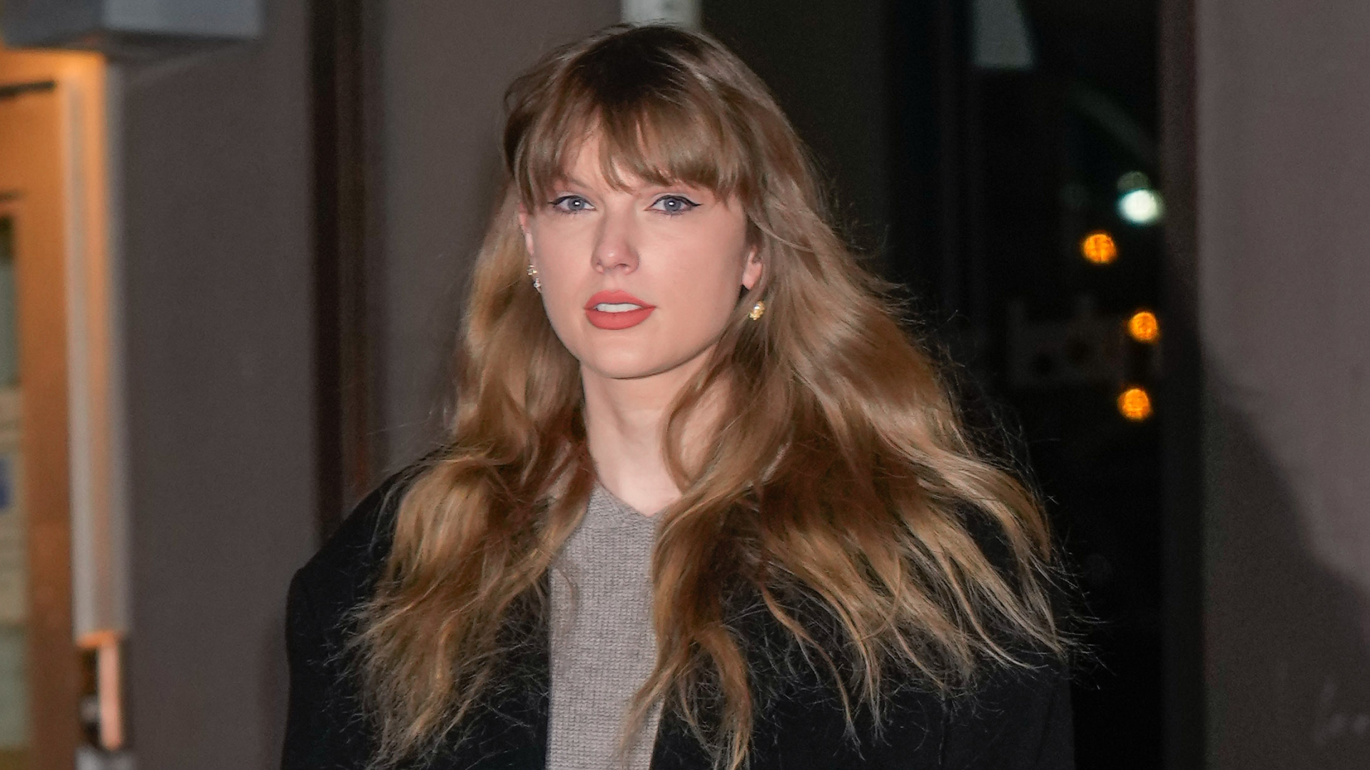 Taylor Swift on January 18, 2024 in New York City wearing a gray sweater and black overcoat