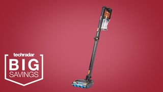 The Shark Anti Hair Wrap Cordless Stick Vacuum Cleaner with PowerFins & Flexology on a pink background