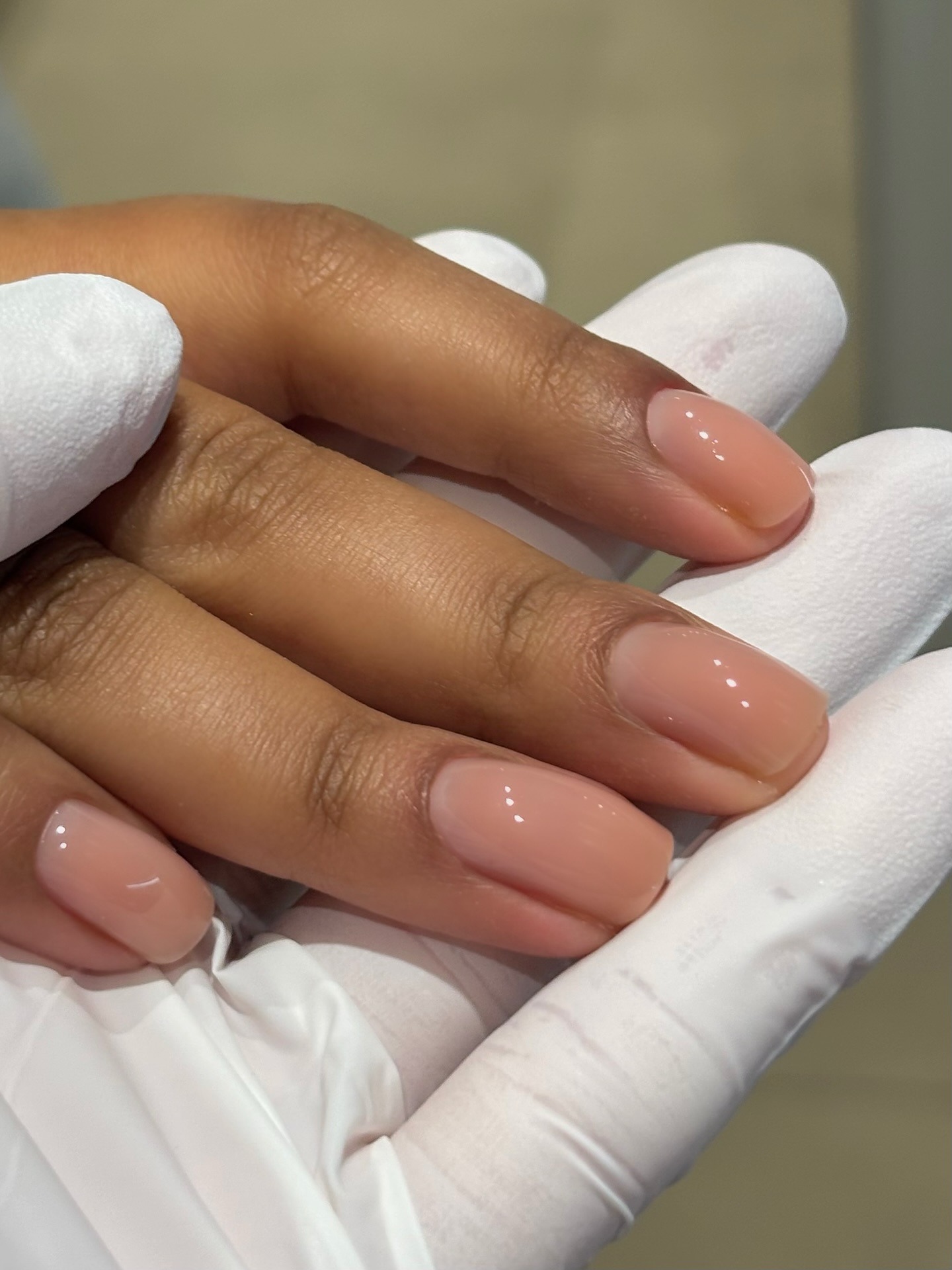 A close-up of a sheer peach manicure