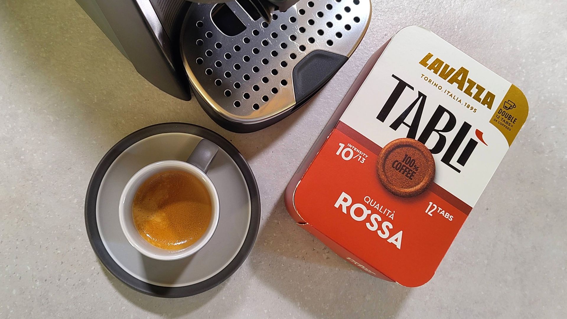 Lavazza Tabli coffee maker with cup of espresso and box of coffee tabs