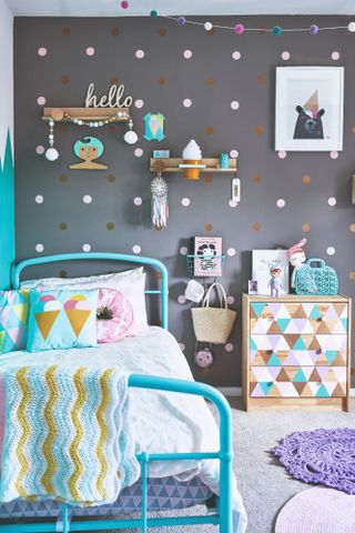 Spillett house: child's room with polkadot wall, blue metal bed, white bedding and geometric blue and white chest of drawers