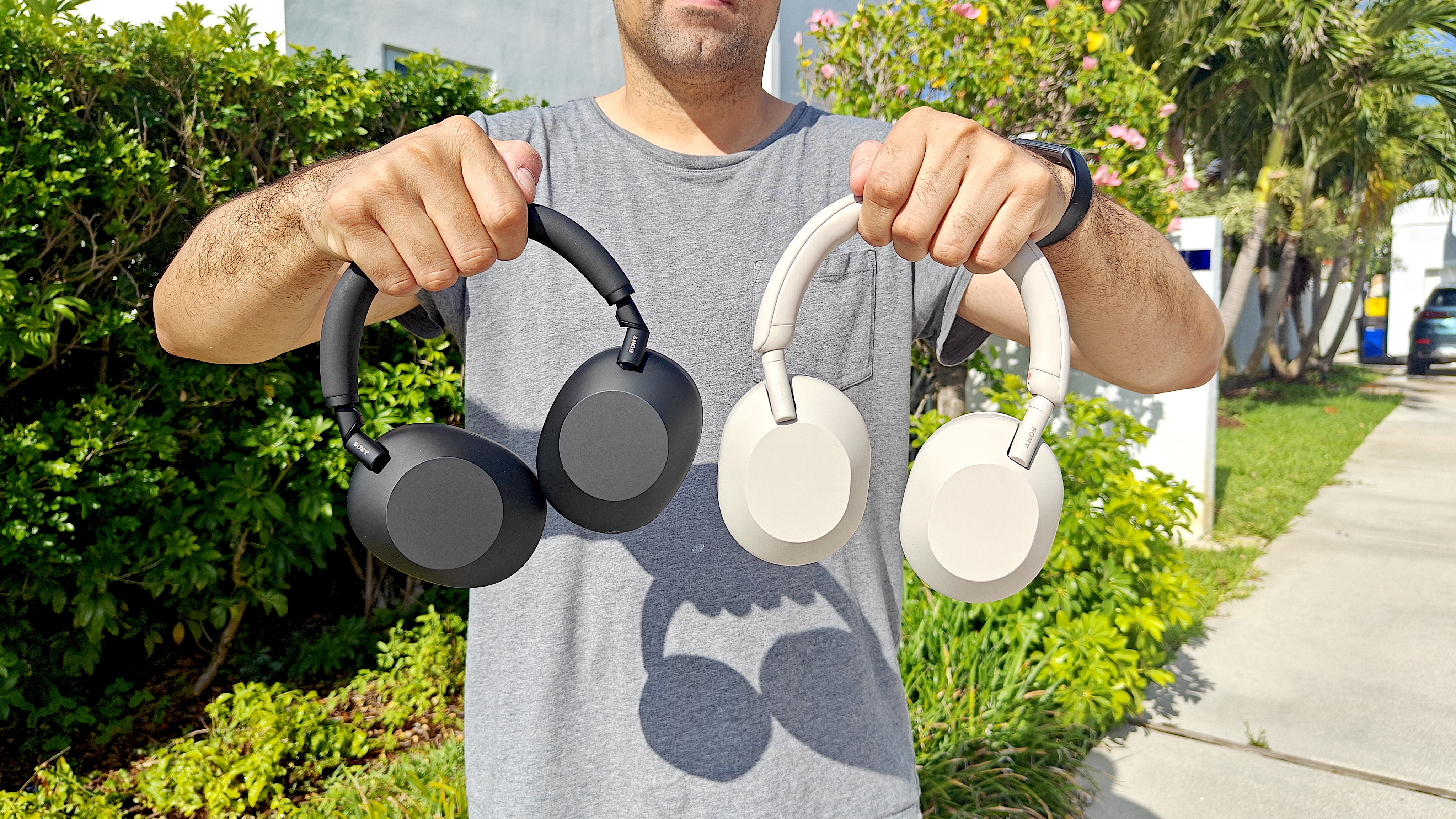 Our reviewer holding both the Sony WH-1000xM6 and Sony WH-1000xM5 headphones