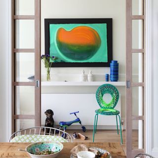 white dining room with table and wall painting