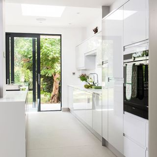 kitchen corridor has bright white wall with a glass door and white kitchen counter