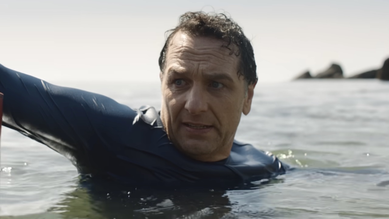 Tom floating in water near buoy looking worried back at seahag in Widow's Bay