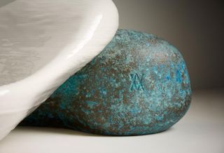 Detail of Daniel Arsham Kohler sink made of 3D printed white ceramic resting on an oxidised brass stone-shaped object
