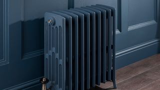 navy blue column radiator next to matching blue wall panelling
