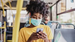 Woman wears a facemask on a bus.