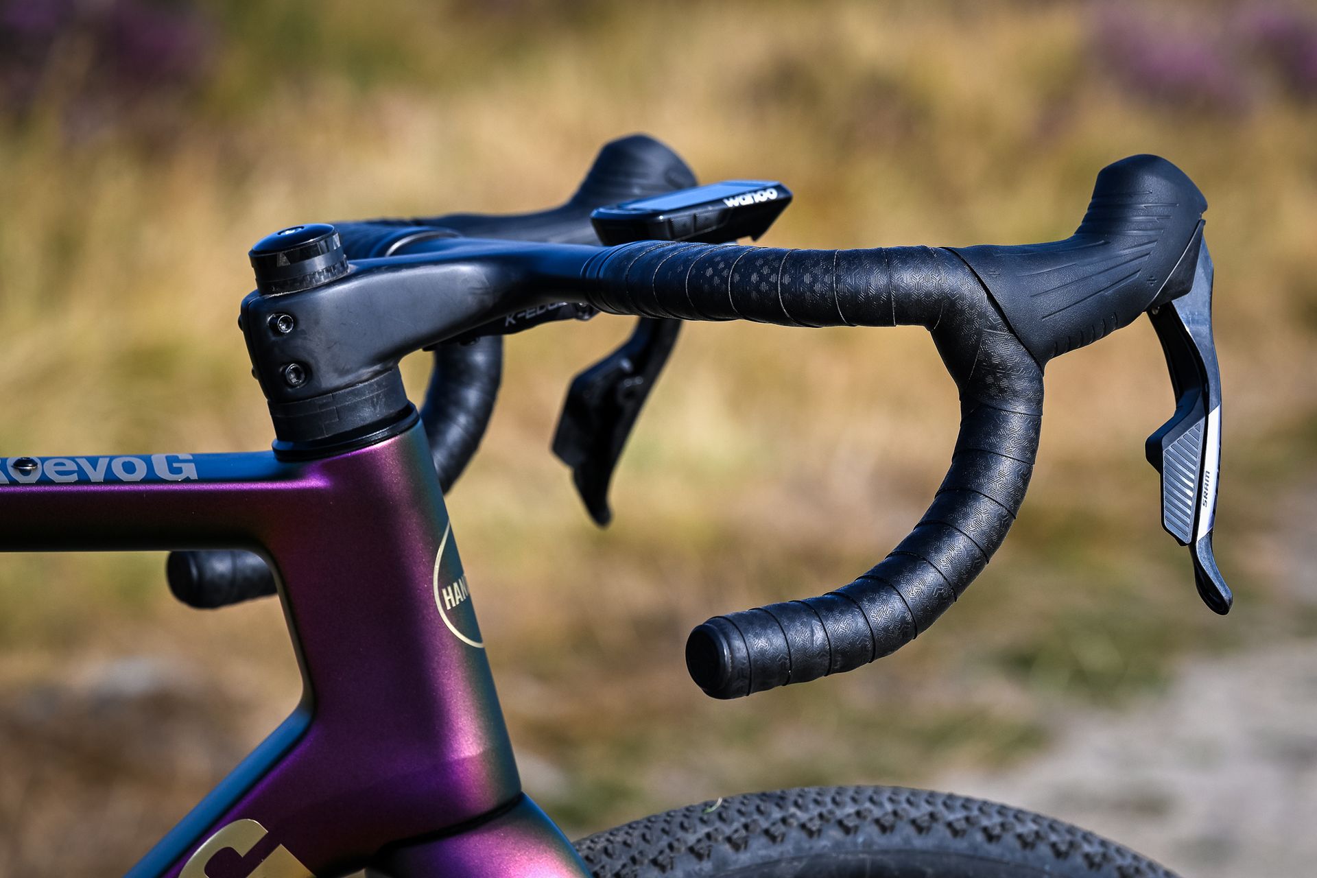 close up of the stem and handlebars on a purple gravel bike