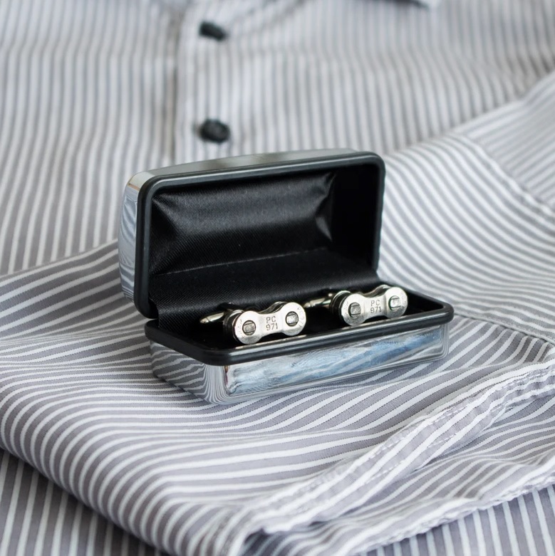 A pair of bike chain cufflinks in a chome box