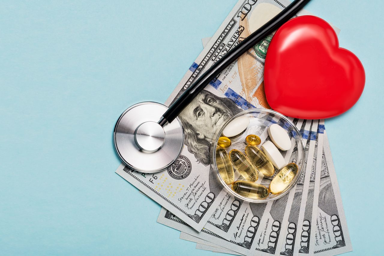 Money for heart disease healthcare and finance on blue background