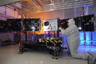 A technician works on the STPSat 3 spacecraft, the largest satellite slated to launch on the Minotaur 1's next mission.