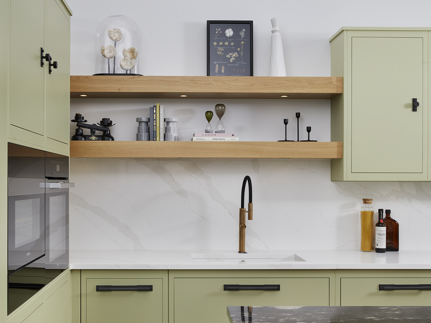 Sage green kitchen cabinets in a green color palette apartment