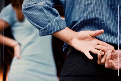 A man removing his wedding ring behind his back