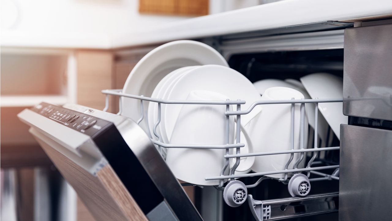 open dishwasher with clean dishes at home kitchen