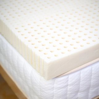 Corner of the Turmerry Latex Mattress Topper on a bed. 