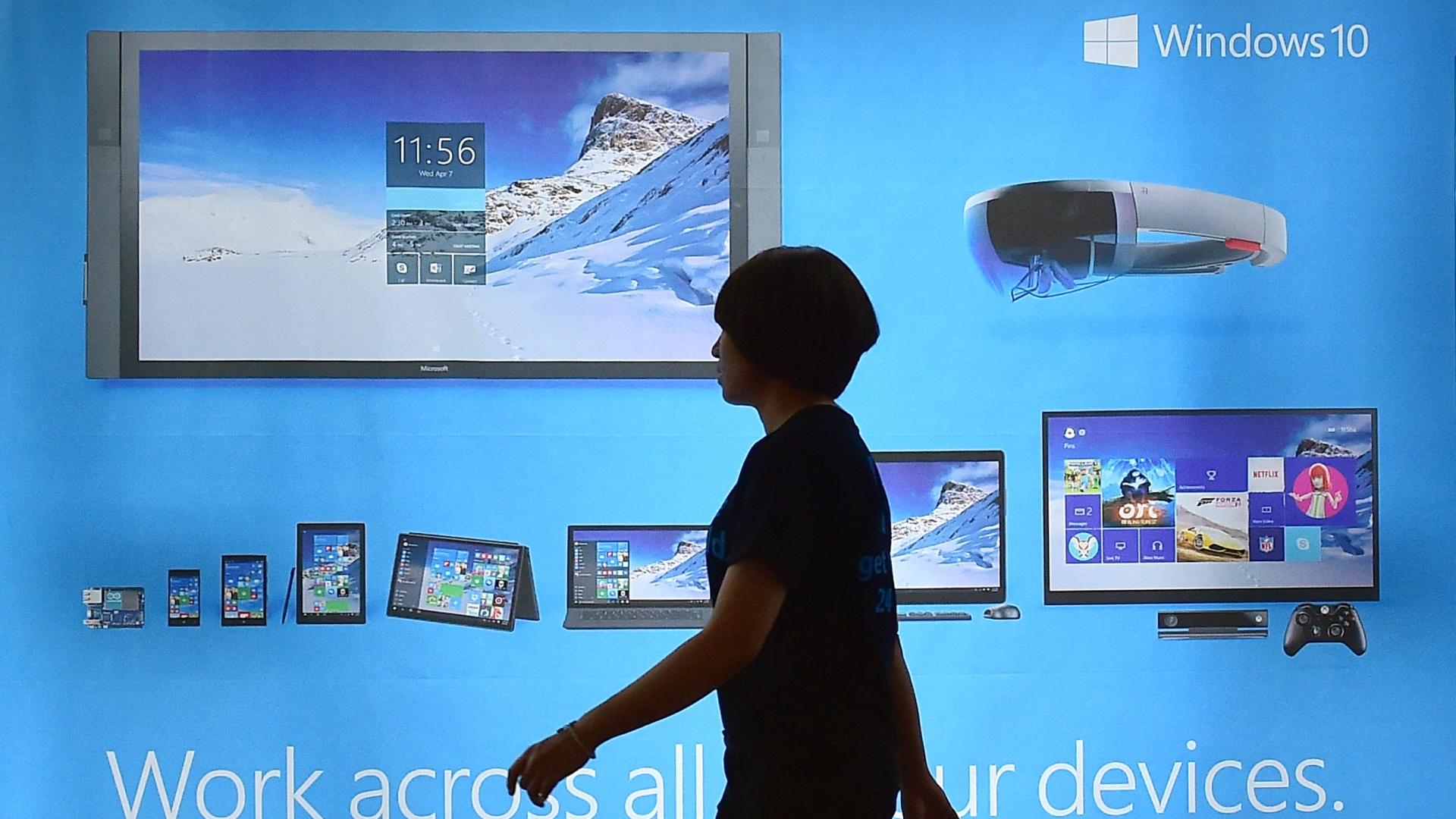 Woman walking past Windows 10 billboard