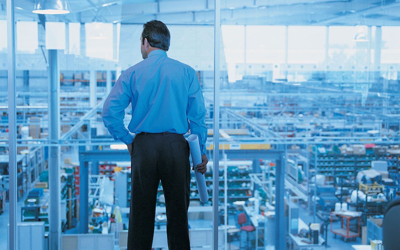 A business executive looks out of his office windows at the city below