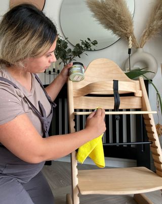 DIY mother polishing and cleaning her baby's newly built baby seat