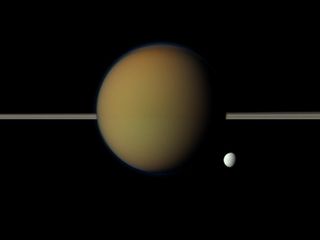 Saturn's moon Tethys peeps out from behind the larger, hazy, colorful Titan in this Cassini view of the two moons.