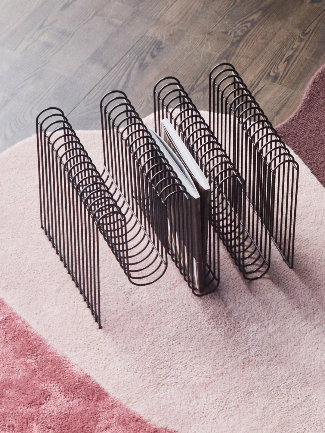 A black curve magazine rack from AYTM