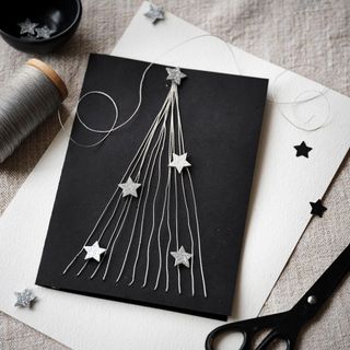 Black Christmas card with silver thread and stars on a white envelope