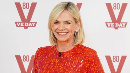 Zoe Ball wearing a red dress smiling for the cameras