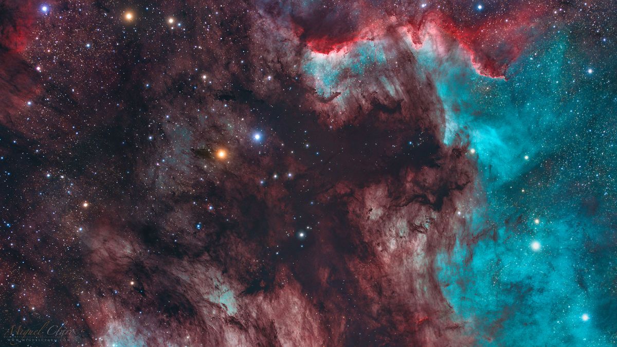 a colorful cloud of gas seen against a backdrop of bright stars in white, blue and red