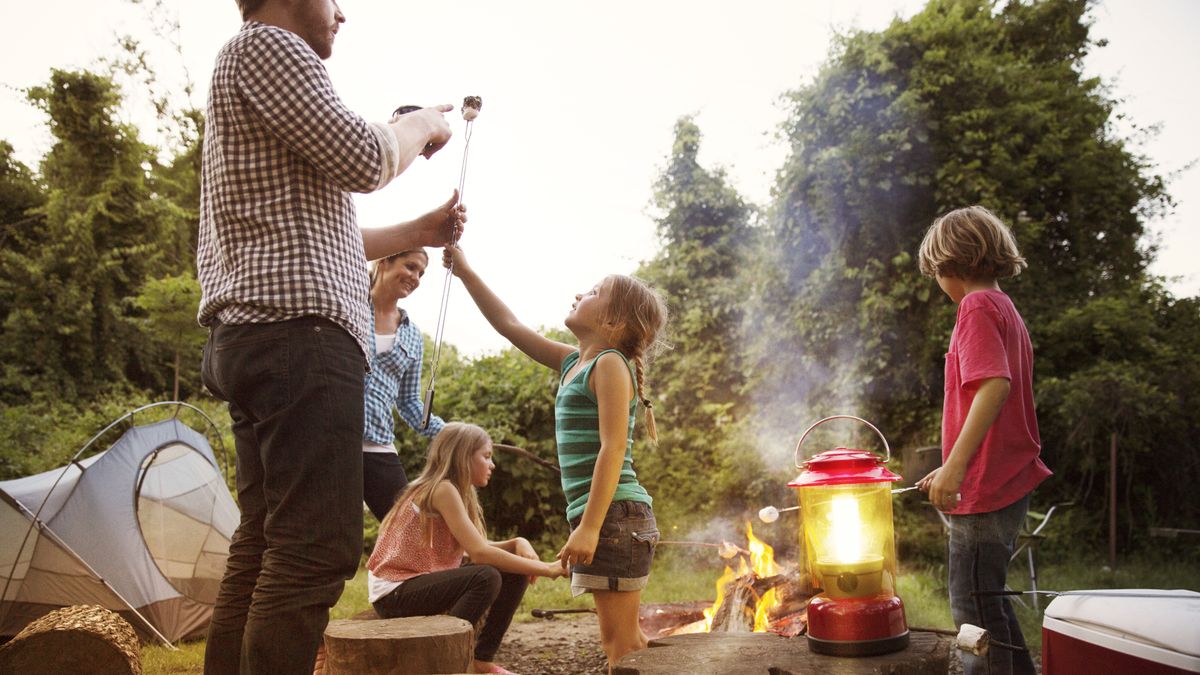 A family of campers roasting marshmallows