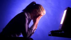 A woman with her head in her hands at her computer