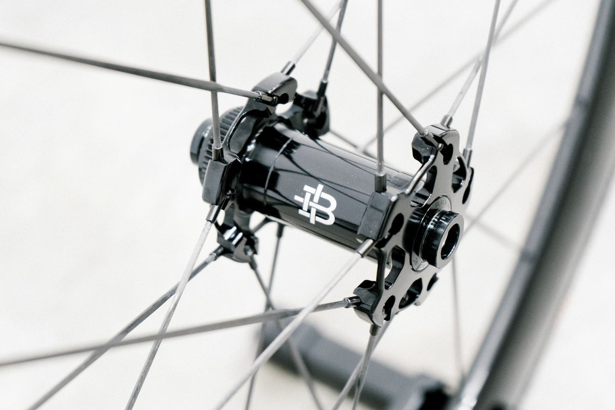 An aero road wheel stands against a white wall